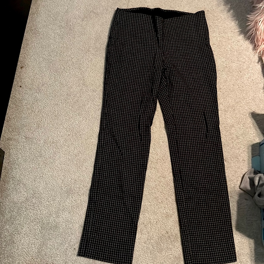 Blk pants white lines, down and cross. Slime 8 zip up on side.